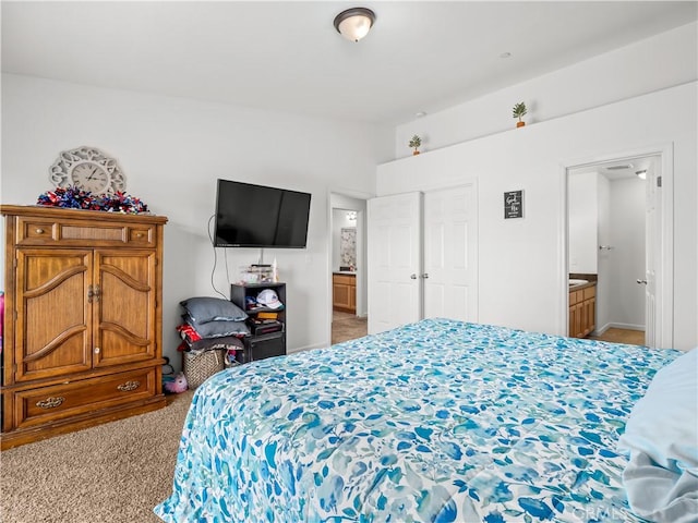 carpeted bedroom featuring lofted ceiling and ensuite bathroom