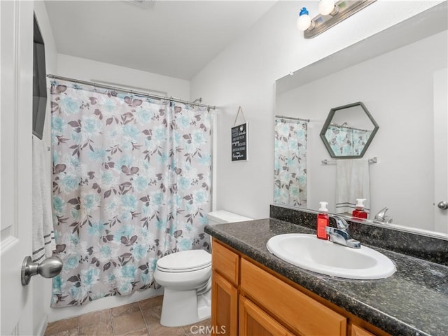 bathroom with curtained shower, vanity, and toilet