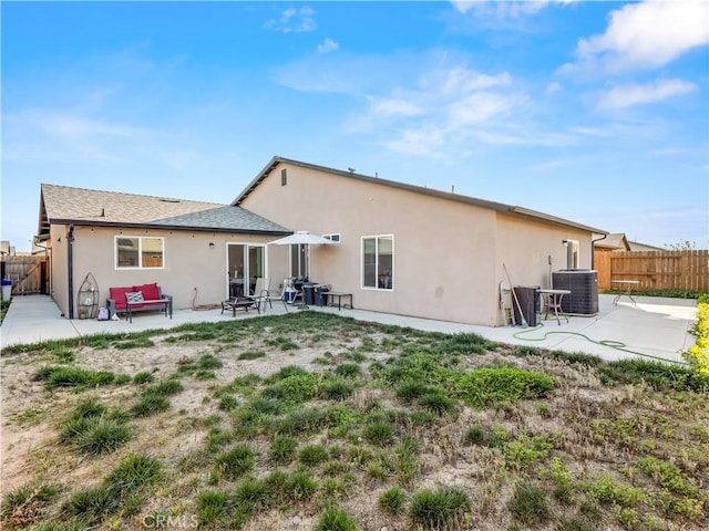 back of property featuring stucco siding, a patio area, fence, and central air condition unit