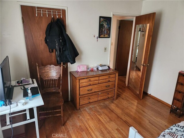 bedroom with light wood-style floors and baseboards