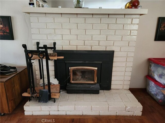 interior details featuring a wood stove and wood finished floors