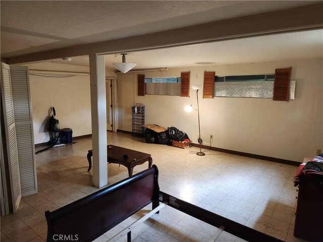 exercise area with baseboards and tile patterned floors