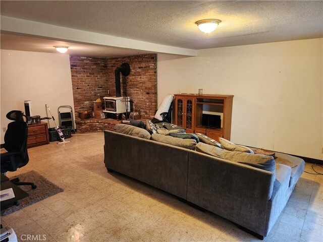 living room featuring a wood stove, a textured ceiling, and light floors