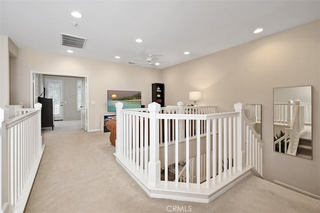 hall featuring recessed lighting, visible vents, carpet flooring, and an upstairs landing