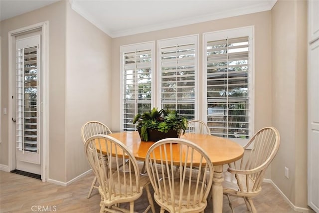 dining space with baseboards, light wood-style floors, plenty of natural light, and crown molding