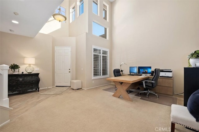 office space featuring carpet floors, a high ceiling, baseboards, and recessed lighting