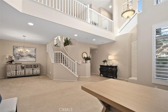 interior space featuring a towering ceiling, baseboards, stairway, and recessed lighting