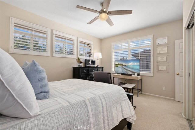 bedroom featuring light carpet, ceiling fan, and baseboards