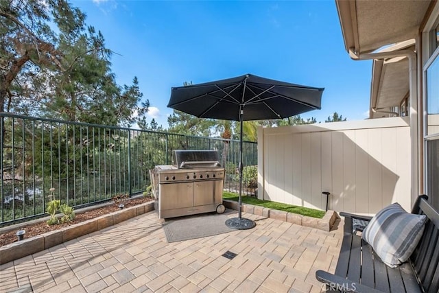 view of patio / terrace featuring a grill and fence