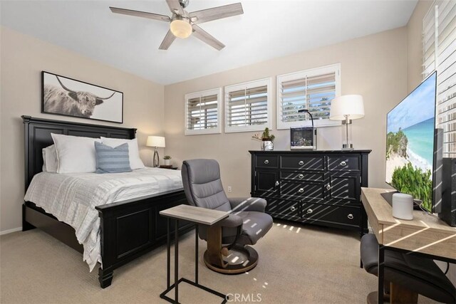 bedroom featuring light carpet, ceiling fan, and baseboards