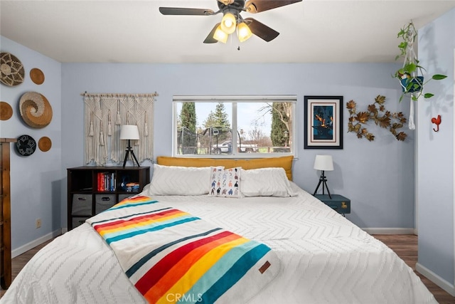 bedroom with baseboards, wood finished floors, and a ceiling fan