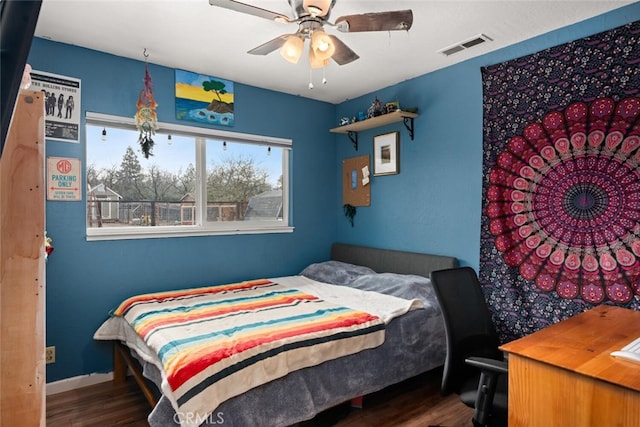 bedroom featuring a ceiling fan, wood finished floors, visible vents, and baseboards