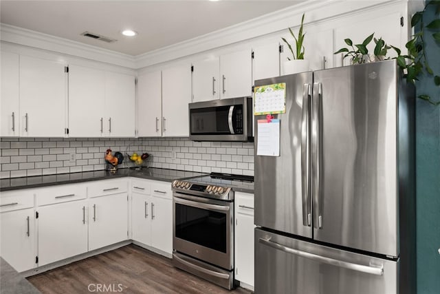 kitchen featuring dark countertops, white cabinets, visible vents, and stainless steel appliances