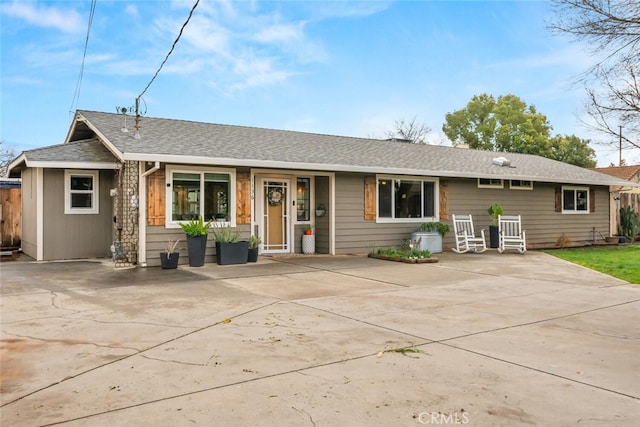 view of front of house featuring fence and roof with shingles