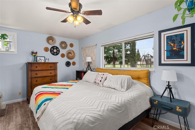 bedroom featuring wood finished floors, baseboards, and ceiling fan