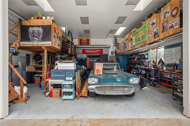 garage featuring stainless steel fridge with ice dispenser