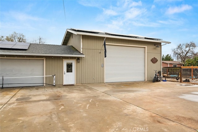 detached garage with roof mounted solar panels and fence