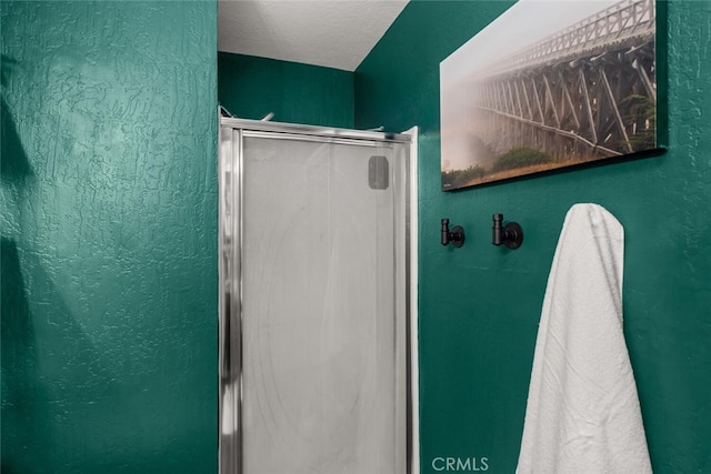 bathroom featuring a textured ceiling and a shower stall