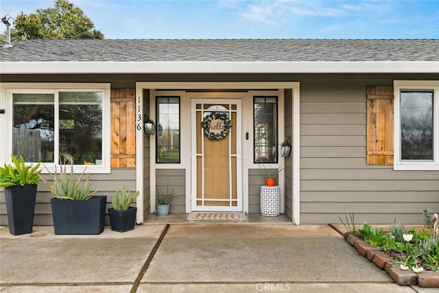 property entrance with a shingled roof