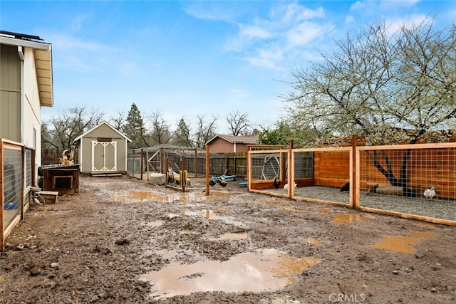 view of yard featuring an outdoor structure, exterior structure, and fence