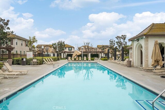 pool featuring a residential view, fence, and a patio