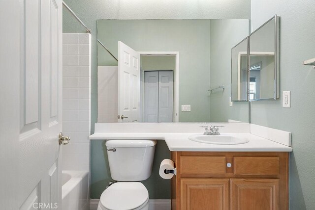 bathroom featuring vanity, toilet, and shower / bathtub combination