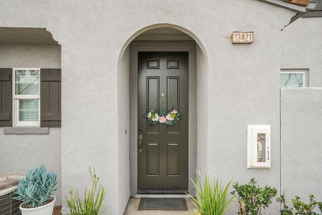 view of exterior entry with stucco siding