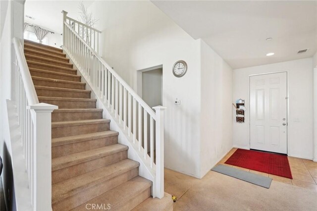 foyer entrance featuring stairs, recessed lighting, carpet, and visible vents