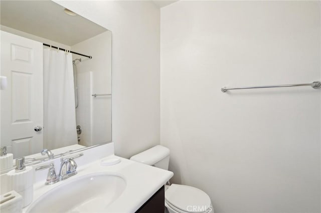 bathroom featuring a shower with shower curtain, toilet, and vanity