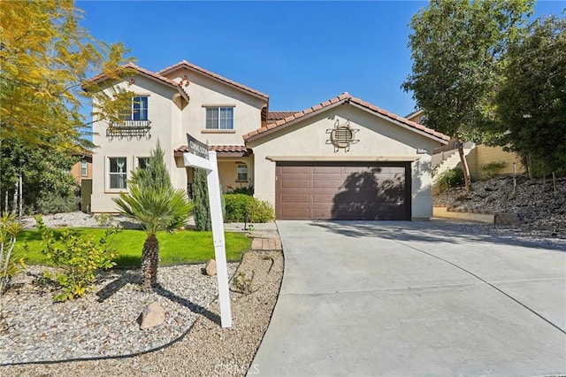 mediterranean / spanish-style home with a tiled roof, stucco siding, an attached garage, and concrete driveway