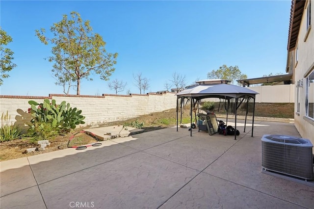 view of patio with a gazebo, cooling unit, and a fenced backyard