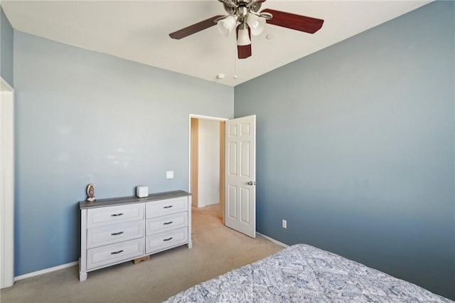 bedroom featuring light colored carpet, baseboards, and ceiling fan