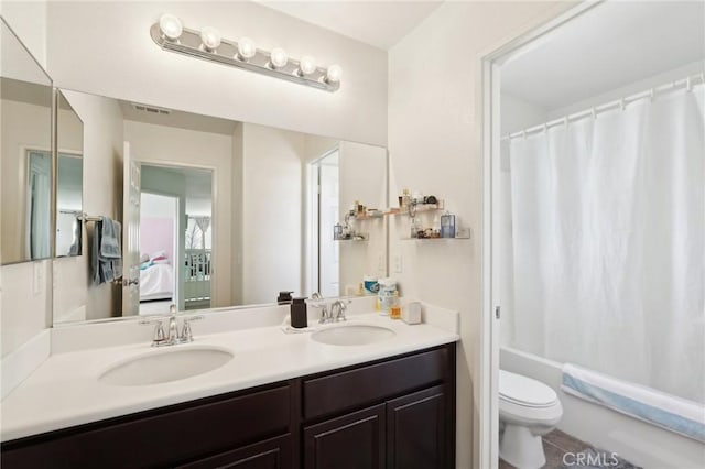 bathroom with double vanity, toilet, shower / bath combo with shower curtain, and a sink