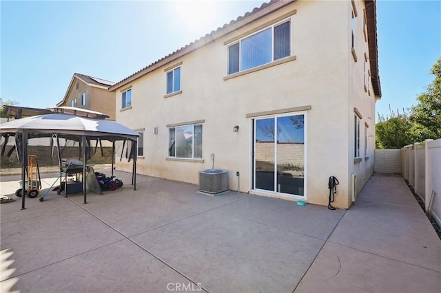 back of property with a patio area, a gazebo, central AC unit, and stucco siding