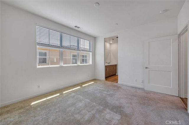 carpeted empty room featuring visible vents and baseboards