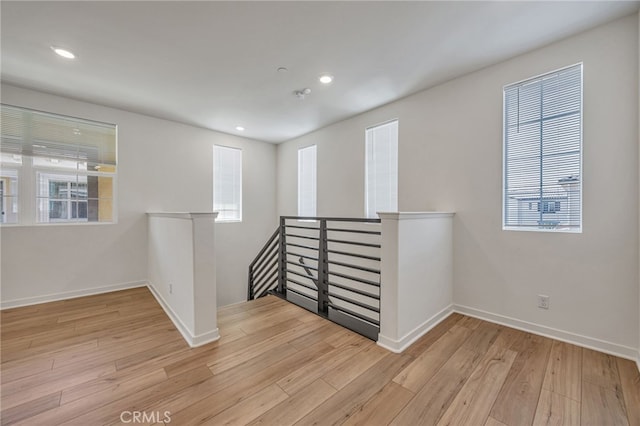 empty room featuring wood finished floors, recessed lighting, and baseboards