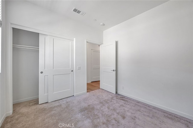 unfurnished bedroom featuring baseboards, visible vents, a closet, and carpet flooring