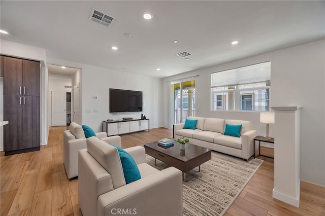 living area featuring visible vents, recessed lighting, baseboards, and light wood-style floors