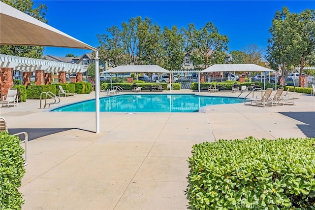 community pool featuring fence and a patio area