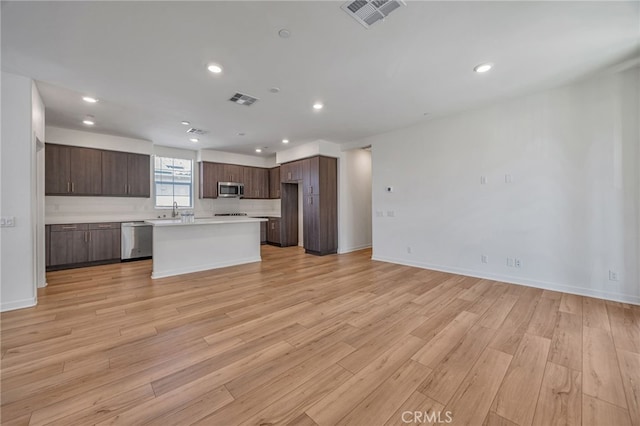 kitchen with visible vents, open floor plan, appliances with stainless steel finishes, and light countertops