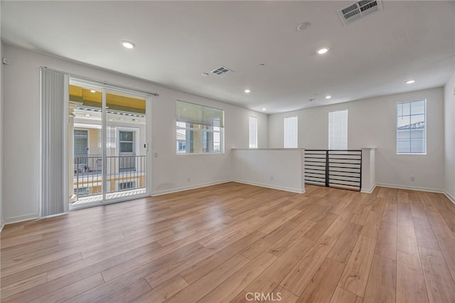 spare room featuring visible vents, baseboards, and light wood-style floors