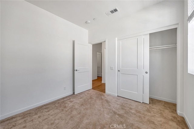 unfurnished bedroom featuring visible vents, a closet, baseboards, and carpet floors