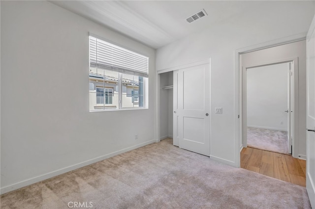unfurnished bedroom with baseboards, visible vents, carpet floors, and a closet