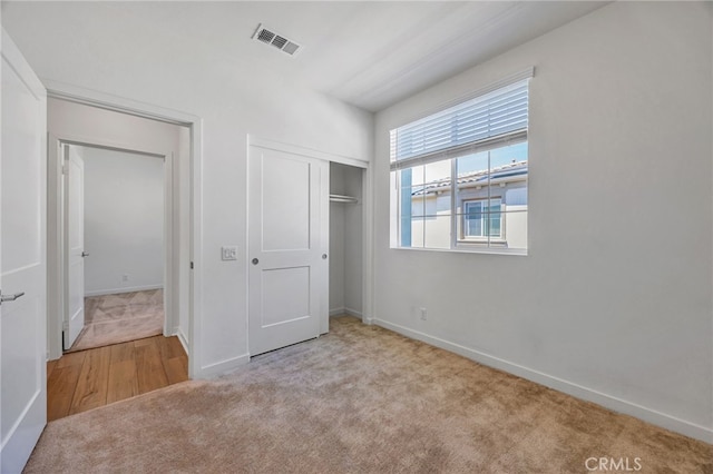 unfurnished bedroom with visible vents, a closet, baseboards, and carpet floors