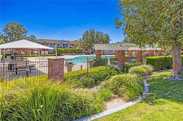 community pool featuring fence, a gazebo, and a yard