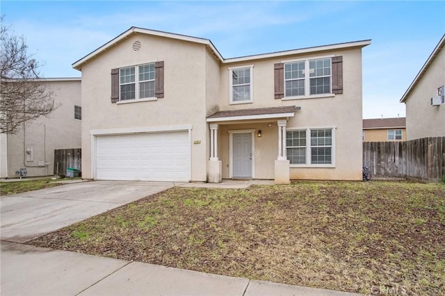 traditional home featuring stucco siding, driveway, a garage, and fence