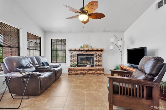 living room featuring visible vents, a ceiling fan, a brick fireplace, baseboards, and tile patterned floors