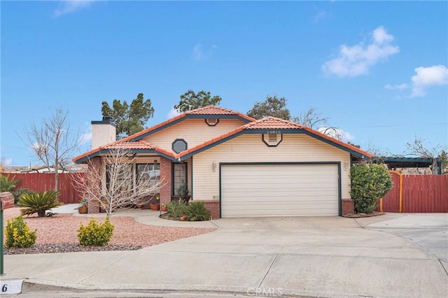 mediterranean / spanish home with brick siding, an attached garage, fence, driveway, and a tiled roof