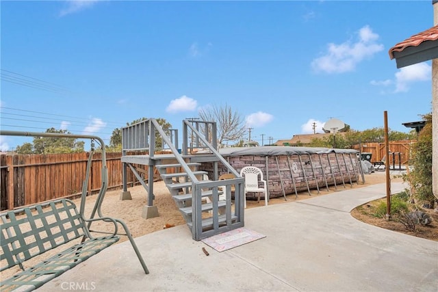 view of playground with a patio area and a fenced backyard