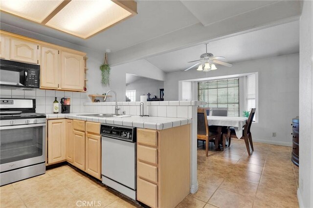 kitchen with white dishwasher, a sink, gas range, black microwave, and a peninsula